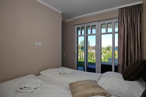 海利根达姆Linden-Palais Wohnung 01的卧室配有一张大白色床和窗户