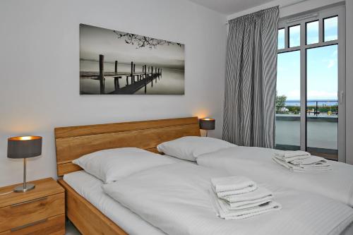 海利根达姆Linden-Palais Wohnung 16的一间卧室设有两张床,享有码头的景色