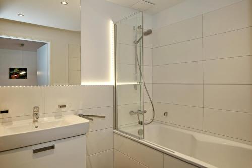 海利根达姆Linden-Palais Wohnung 02的一间带玻璃淋浴和水槽的浴室