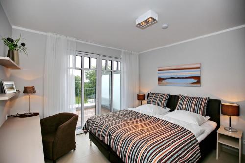 海利根达姆Linden-Palais Wohnung 37的卧室配有床、椅子和窗户。