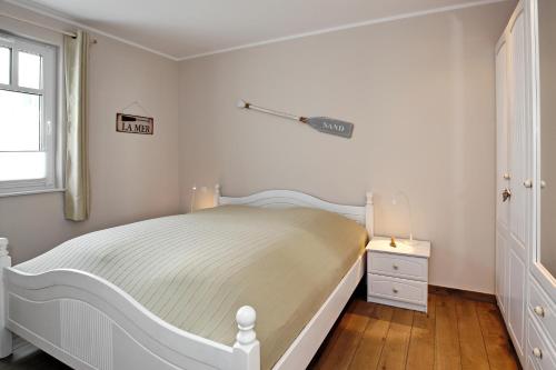 海利根达姆Linden-Palais Wohnung 09的白色的卧室设有白色的床和窗户。