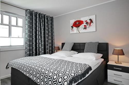 海利根达姆Linden-Palais Wohnung 23的卧室设有黑白床和窗户。