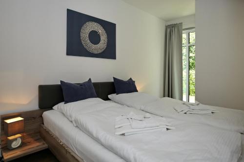 海利根达姆Linden-Palais Wohnung 08的一张配有白色床单和蓝色枕头的大床
