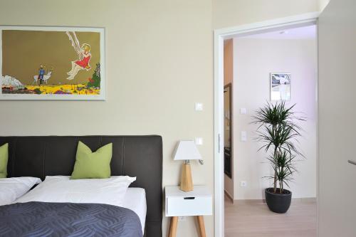 海利根达姆Linden-Palais Wohnung 10的一间卧室配有一张带绿色枕头和植物的床