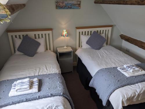 惠特比Whitby Sea View Cottage的带灯的客房内的两张单人床