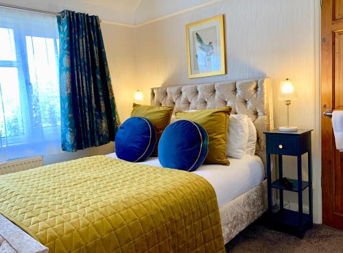 史云顿SW住宿加早餐酒店的一间卧室配有一张带两个蓝色枕头的床