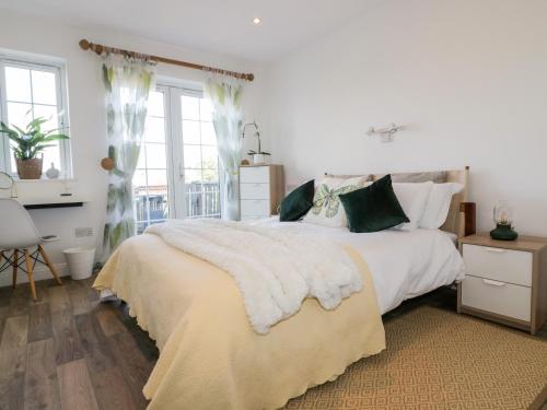 廷塔杰尔Badgers Way的卧室配有带绿色枕头的大型白色床