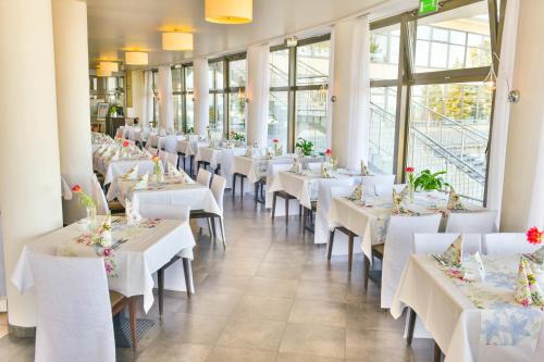 科沃布热格Sanatorium Uzdrowiskowe Bałtyk的餐厅里一排桌子,有白色的桌子和椅子