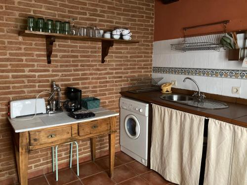 Villanueva del CondeCasa rural Adelaida的厨房配有水槽和洗衣机