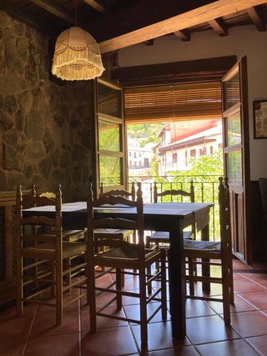 Villanueva del CondeCasa rural Adelaida的一间带桌椅和窗户的用餐室