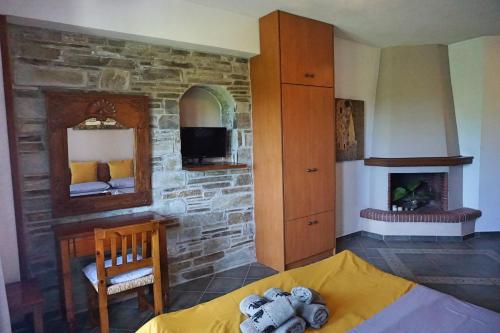 桑加拉达Artemisia House的一间卧室设有石墙、一张床和一个壁炉