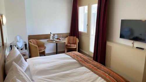 蓬泰特雷萨特雷萨湾酒店的酒店客房设有一张床和一张小桌子。