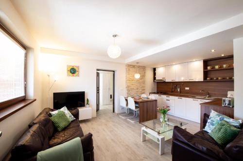班斯卡-比斯特里察Apartman MANDALA的客厅以及带沙发和桌子的厨房。