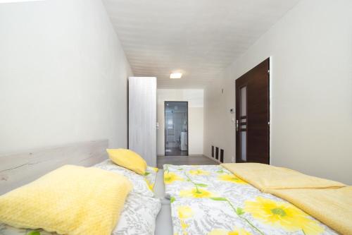 班斯卡-比斯特里察Apartman MANDALA的一间卧室配有一张带黄色枕头的床。