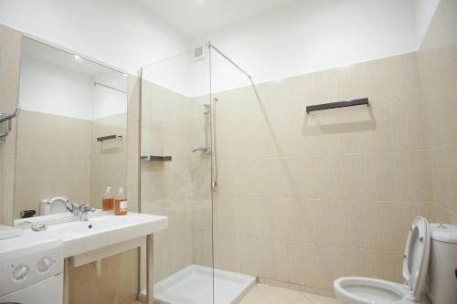 科帕罗Seaside Duplex Stone Villa的带淋浴、盥洗盆和卫生间的浴室