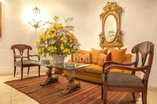 利马Antara Hotel & Suites - Miraflores的客厅配有沙发和鲜花桌