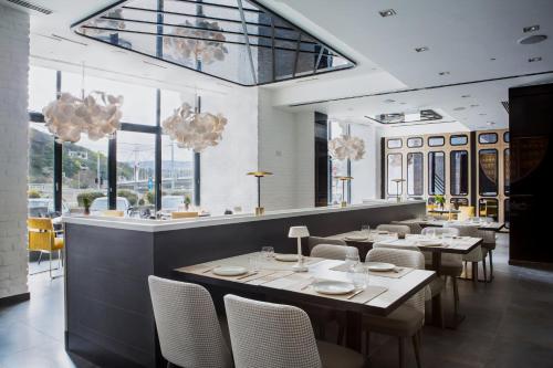 布达佩斯Hotel Vision的用餐室设有桌椅和窗户。