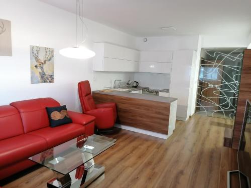 布拉迪斯拉发Foreta的一间带红色沙发的客厅和一间厨房