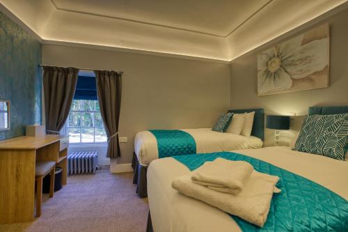 BackiesGolspie Inn的酒店客房配有两张床和一张书桌