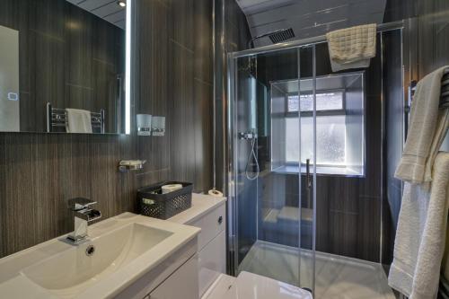BackiesGolspie Inn的一间带水槽和玻璃淋浴的浴室