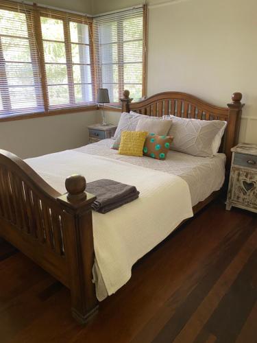 比尔瓦Coochin Cottage, Beerwah的一间卧室配有一张带枕头的大型木制床。