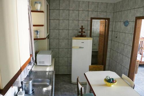 巴拉那州蓬塔尔Apartamento Beira Mar的厨房配有2张桌子和冰箱
