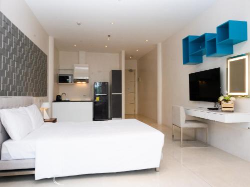 马尼拉City Park Hotel Residences的一间带白色床的卧室和一间厨房