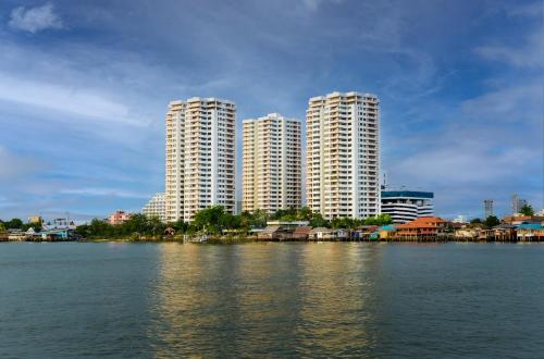 暖武里府Riverine Place Hotel and Residence的两座高楼,位于水岸