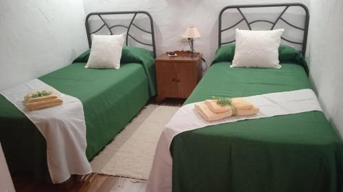 El CercadoCasa Osciris的配有两张床铺的客房提供绿色床单和毛巾