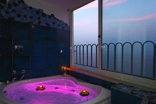 阿马尔菲拉宁法酒店的一间带粉色浴缸的浴室和窗户