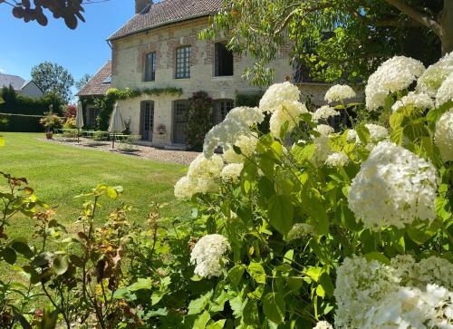 翁弗勒尔La Maison d'Aline - Honfleur - Maison d'Hôte De Charme A La Normande的一座花园,在房子前有白色的花朵
