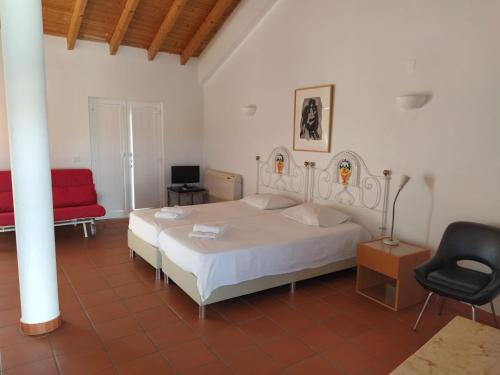 塔维拉Casa da Osga的卧室配有白色的床和红色椅子