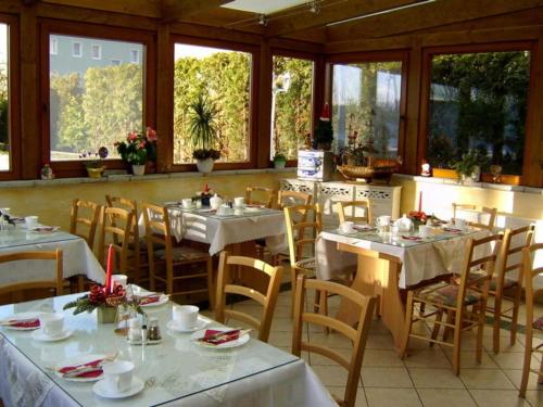 黑灵斯多夫Pension Mittag的餐厅设有白色的桌椅和窗户。