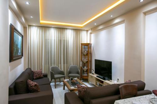卡瓦拉Moza House的带沙发和电视的客厅