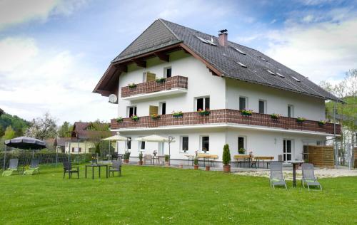 Strass im AttergauApartment Haus Sagerer near Attersee and Mondsee的一座大型白色房子,在田野里配有桌椅