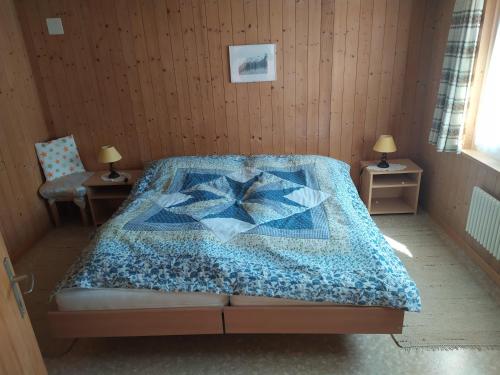 布里恩茨2 Zimmerwohnung Homestay Brienz Spanischgässli的一间卧室配有床,床上装有被子