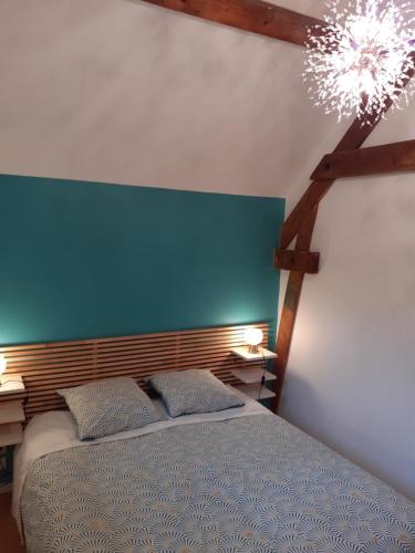 VernaisonLa Fée des Eaux的一间卧室配有蓝色床头板和一张带两个枕头的床