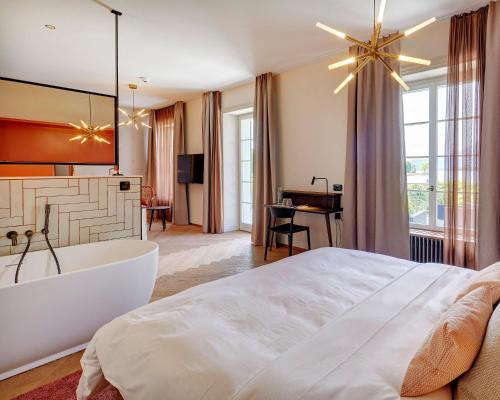 屈斯纳赫特Hotel Restaurant Seehof的卧室配有一张白色大床和浴缸