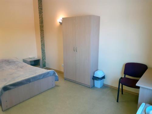 NeveronysKambarių nuoma - Neveronys SAURIDA的一间卧室配有一张床、一个橱柜和一把椅子