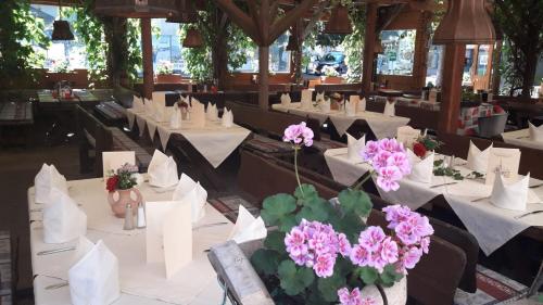 克森Gasthof Erzherzog Rainer - Zimmer und Ferienwohnung的用餐室配有白色的桌子和粉红色的鲜花