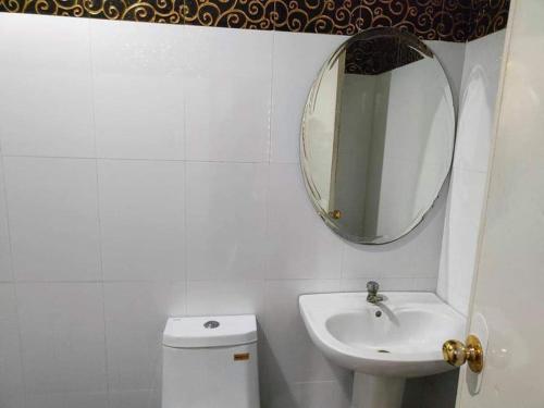 美岸RedDoorz @ Villa E Mansion的一间带水槽、镜子和卫生间的浴室