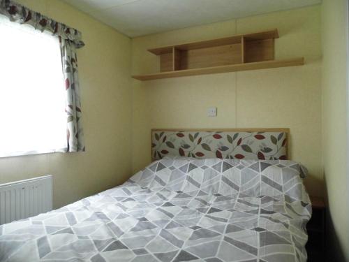 威利Oakdene -3 Bedroom Caravan的一间卧室设有一张床和一个窗口