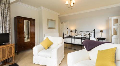 牛顿莫尔考伊纳施旅馆的客厅配有2把白色椅子和1张床