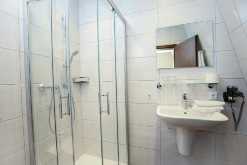 盖瑟尔温德斯特恩酒店及餐厅的白色的浴室设有水槽和淋浴。