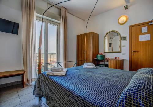 里乔内Hotel Nizza - SeaView BeachFront Park Hotel的一间卧室配有蓝色的床和镜子
