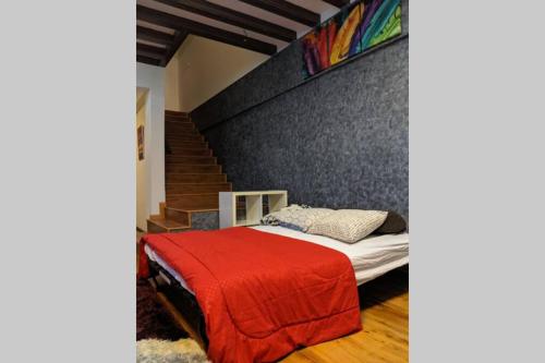 安邦Cozy designer loft near KL city center的一间卧室配有一张带红色毯子的床