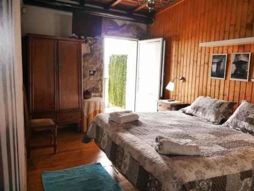 潘通Casa dos Muros turismo rural y actividades en la Ribeira Sacra的一间卧室设有一张大床和一个窗户。