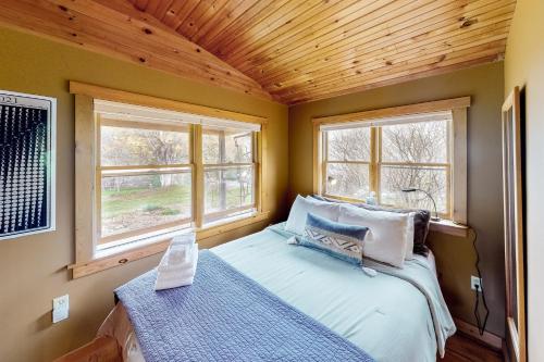 MoretownVT Guest Cottage的一间小卧室,配有床和2个窗户