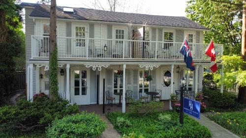 滨湖尼亚加拉Harrogate House Inn的前面有两面旗帜的白色房子