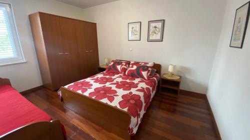 马卡尔斯卡Makarska Apartment Marijo的一间卧室配有一张带红色和白色棉被的床